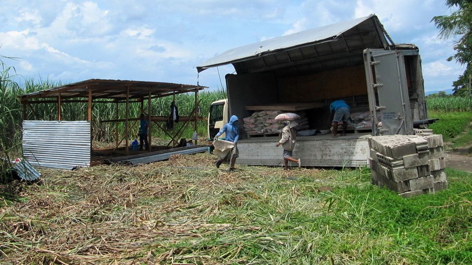 Workers unloading materials for fence construction.