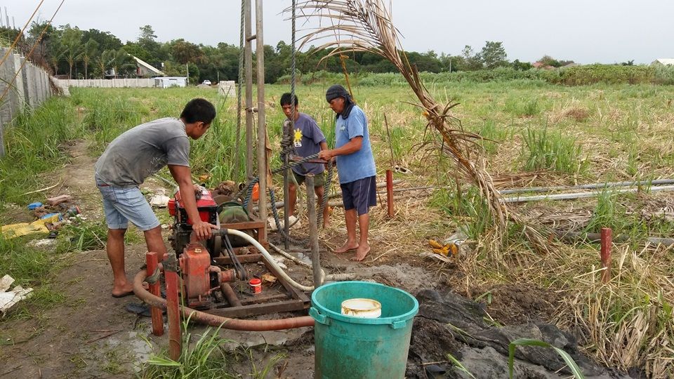 Workers excavating the deep well on the site.